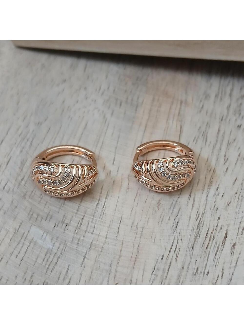 Rose gold hoop earrings with diamond accents and wave-like design